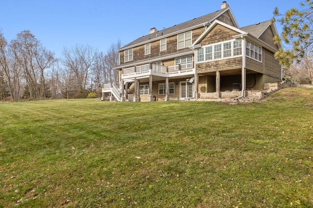 rear view of house with stairway, a yard, a chimney, and a wooden deck