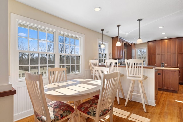 dining space with light wood-type flooring, wainscoting, and recessed lighting