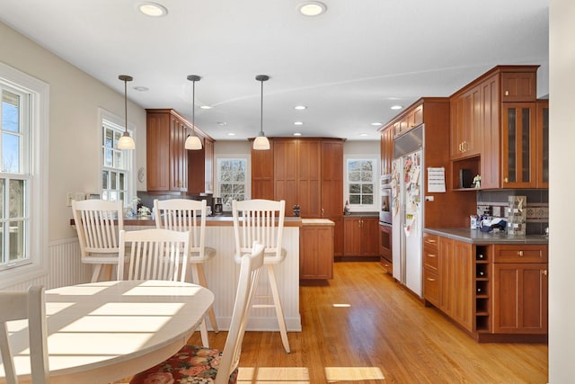 kitchen featuring open shelves, brown cabinets, and pendant lighting