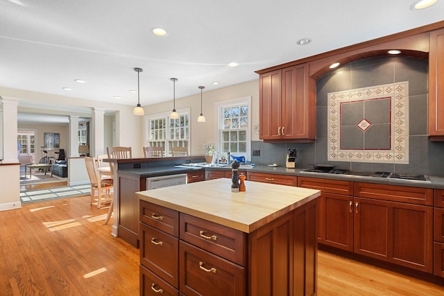 kitchen with a center island, pendant lighting, decorative columns, light wood-style flooring, and wood counters