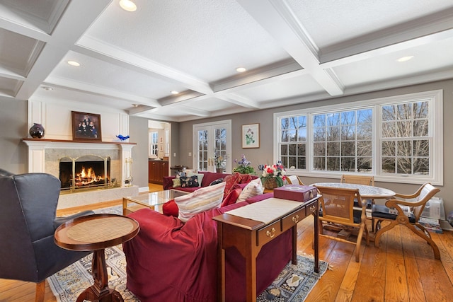 living room featuring coffered ceiling, hardwood / wood-style flooring, beamed ceiling, a fireplace, and recessed lighting