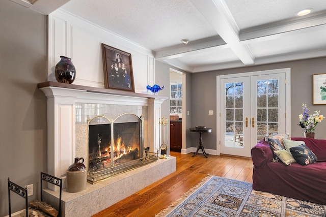 interior space featuring coffered ceiling, french doors, light wood-type flooring, beam ceiling, and crown molding