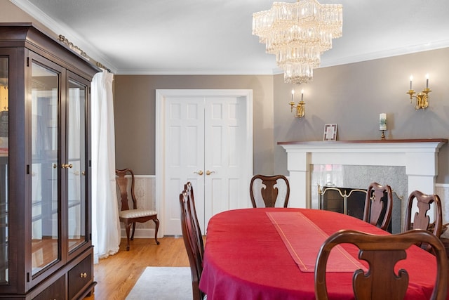 dining space with light wood-style flooring, ornamental molding, and a chandelier