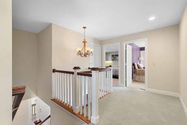 corridor featuring baseboards, light colored carpet, an inviting chandelier, an upstairs landing, and recessed lighting