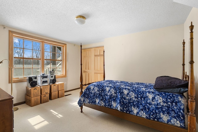 bedroom with a textured ceiling, light carpet, and baseboards