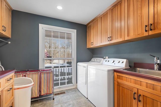 washroom with light tile patterned floors, cabinet space, visible vents, a sink, and separate washer and dryer