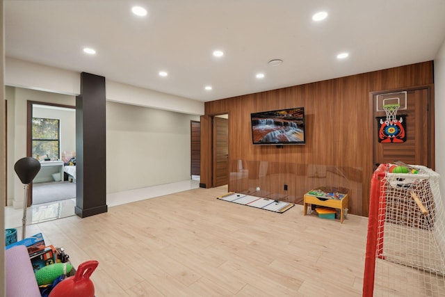 rec room featuring wood walls and hardwood / wood-style flooring