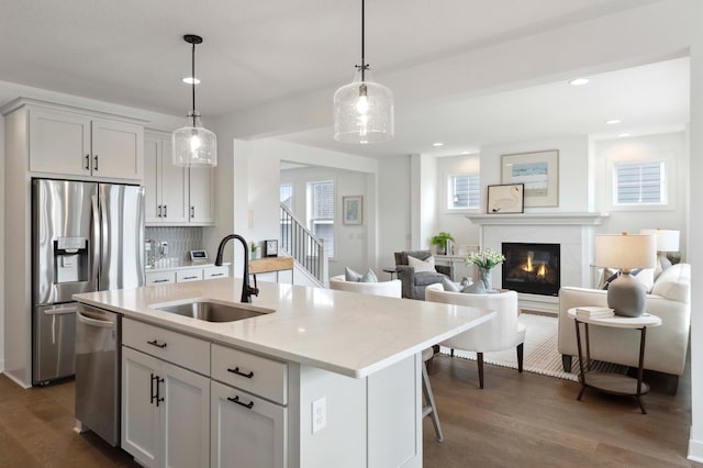 kitchen featuring sink, an island with sink, and white cabinets