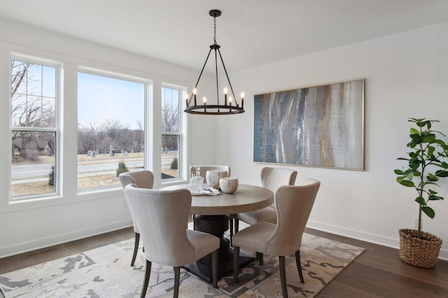 dining area with dark wood-type flooring and a chandelier