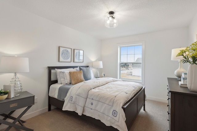 bedroom featuring a textured ceiling and light colored carpet