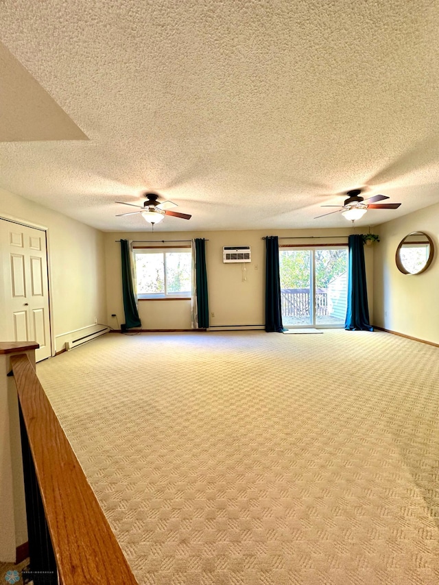 carpeted empty room with a textured ceiling, a wall unit AC, and ceiling fan