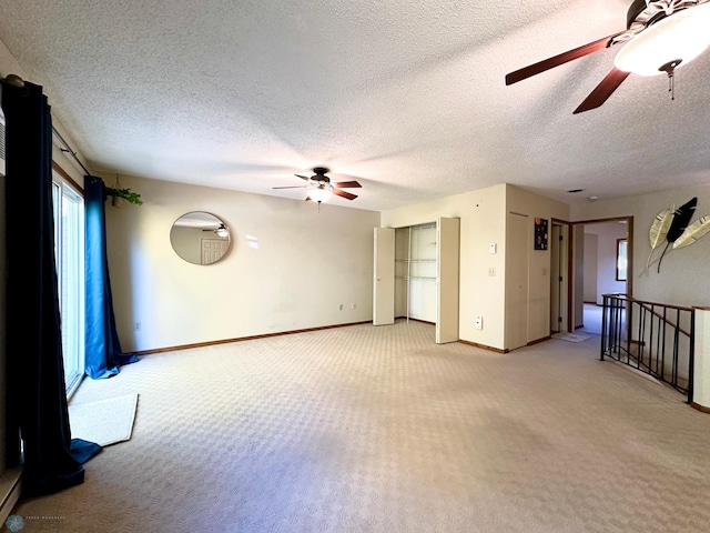 unfurnished room featuring ceiling fan, carpet floors, and a textured ceiling