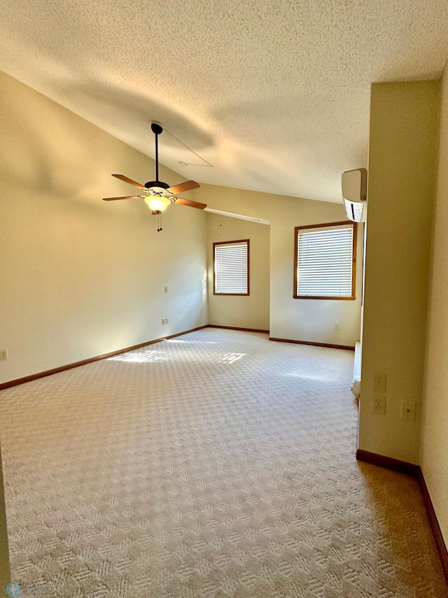 carpeted spare room with ceiling fan, lofted ceiling, and a textured ceiling