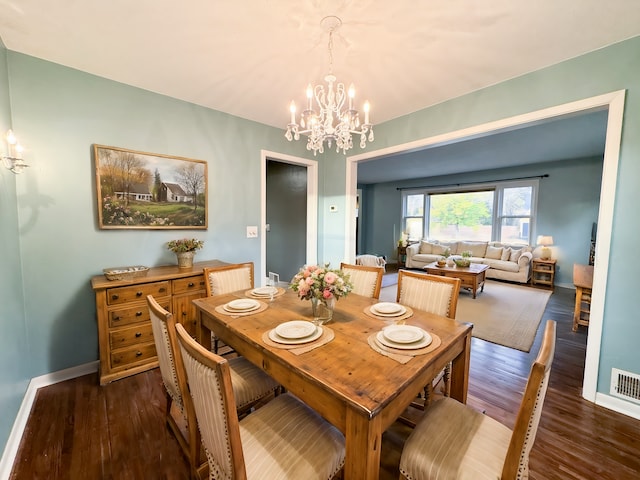 dining space featuring dark hardwood / wood-style floors and a chandelier