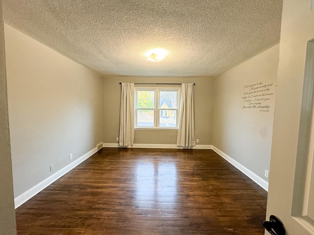 unfurnished room with a textured ceiling and dark hardwood / wood-style flooring