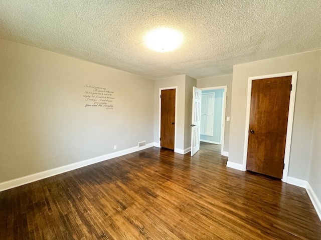 unfurnished bedroom featuring a closet, a textured ceiling, and dark wood-type flooring