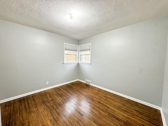 unfurnished room with hardwood / wood-style floors and a textured ceiling