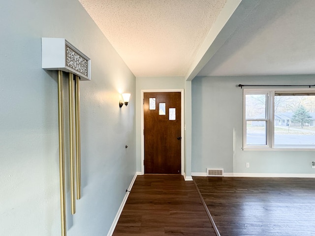 entrance foyer featuring dark wood-type flooring and a textured ceiling