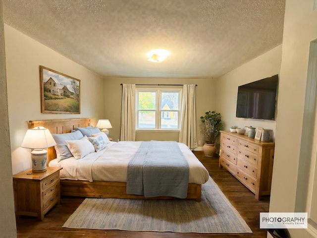 bedroom featuring a textured ceiling and dark hardwood / wood-style flooring