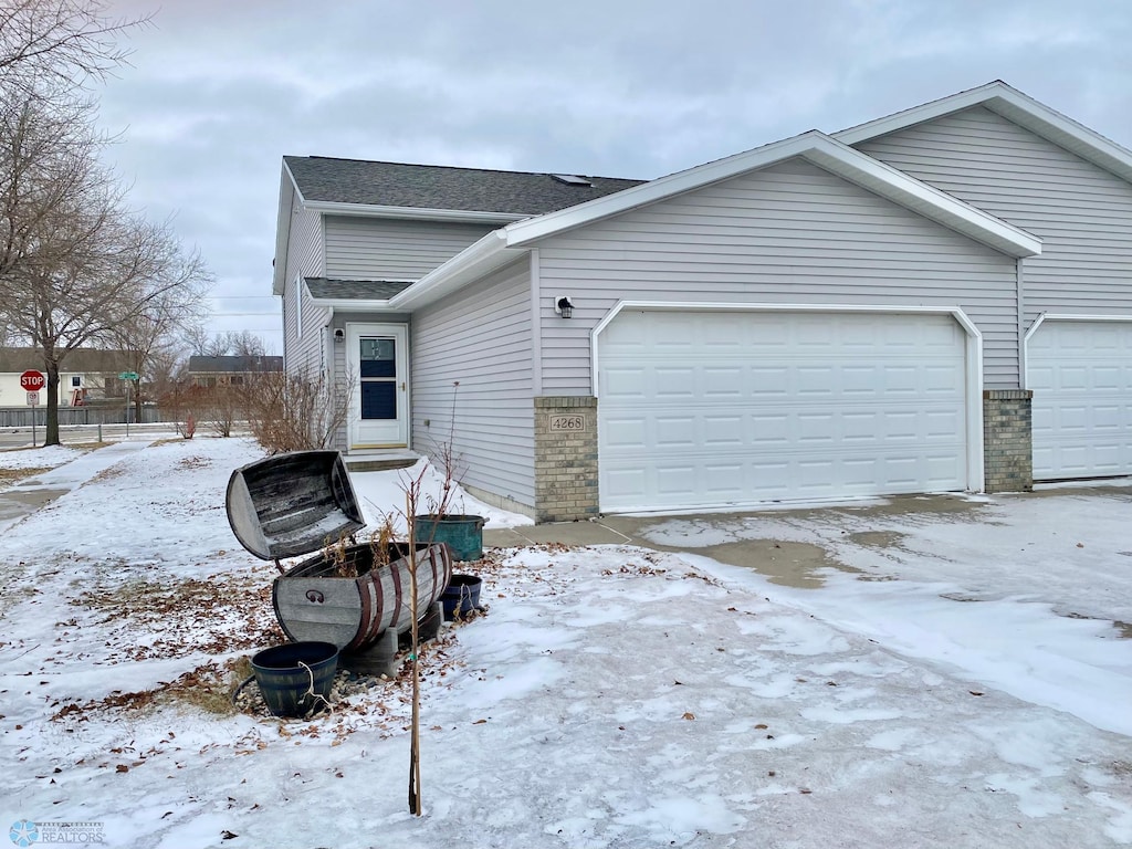 view of snow covered exterior featuring a garage