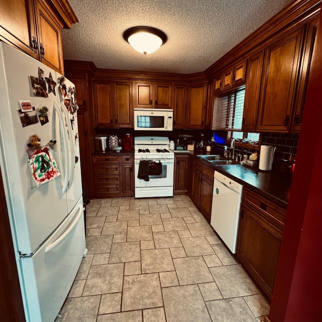 kitchen featuring a textured ceiling, decorative backsplash, sink, and white appliances