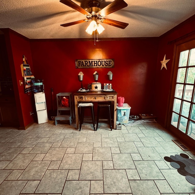 dining space featuring ornamental molding, a textured ceiling, and ceiling fan