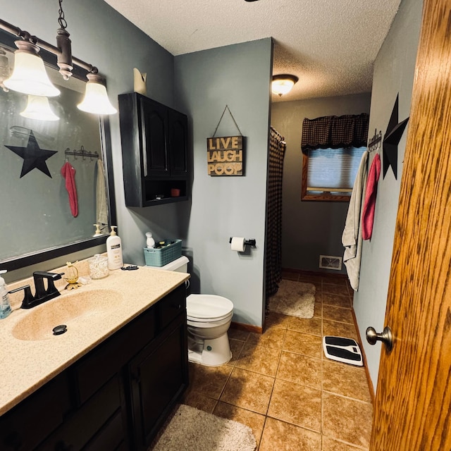 bathroom with toilet, a textured ceiling, vanity, and tile patterned flooring