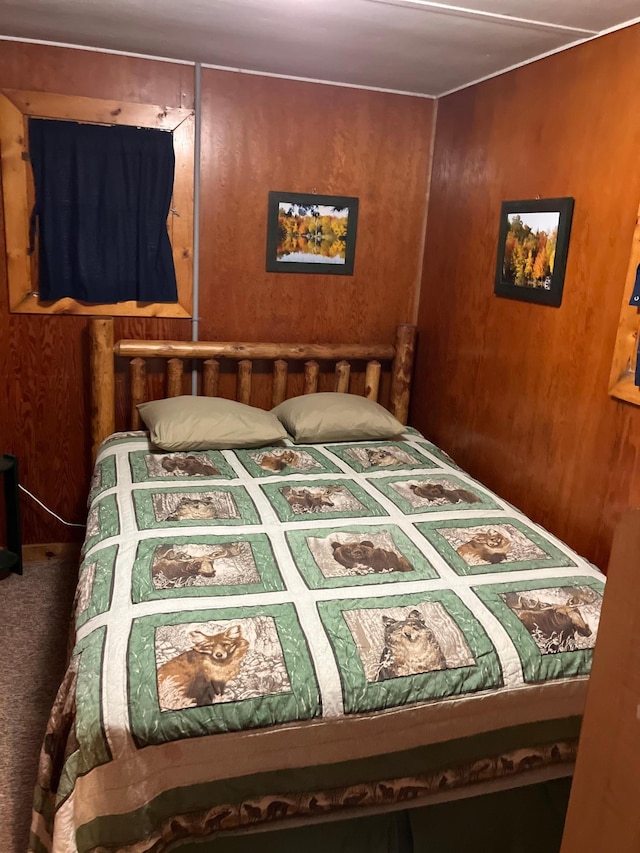 carpeted bedroom featuring wood walls