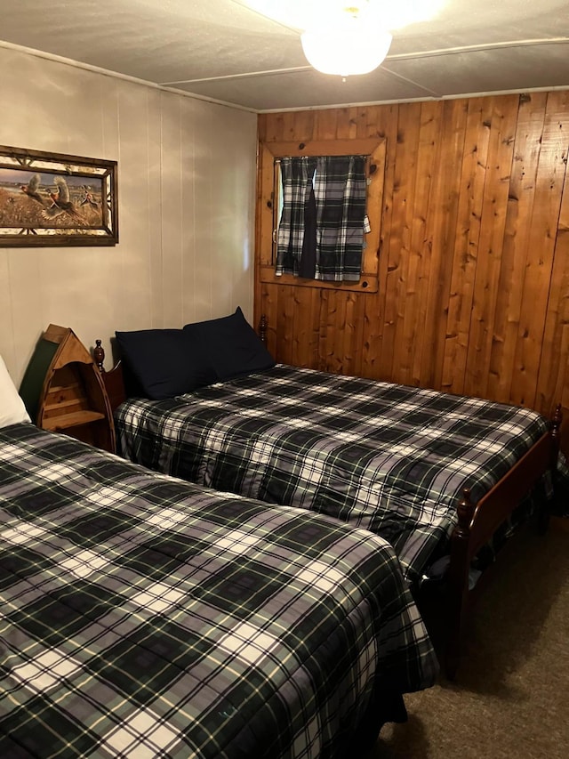 bedroom with wooden walls and carpet flooring