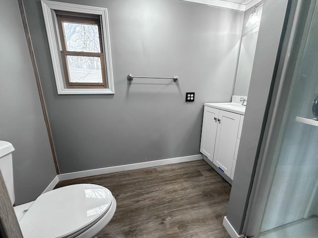 bathroom featuring toilet, hardwood / wood-style floors, vanity, and ornamental molding