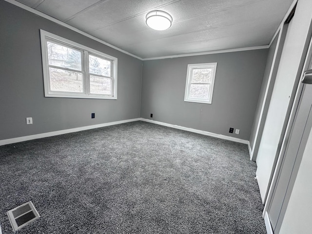 carpeted spare room featuring ornamental molding and a textured ceiling