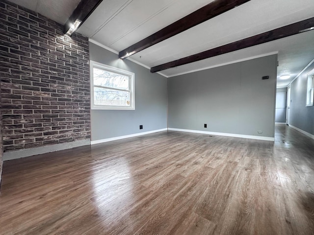 spare room with ornamental molding, beam ceiling, and wood-type flooring