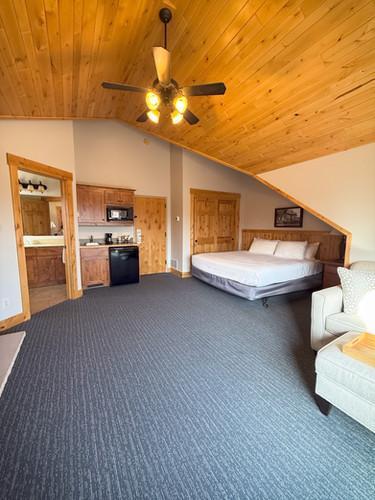 unfurnished bedroom with lofted ceiling, ensuite bath, wooden ceiling, and ceiling fan