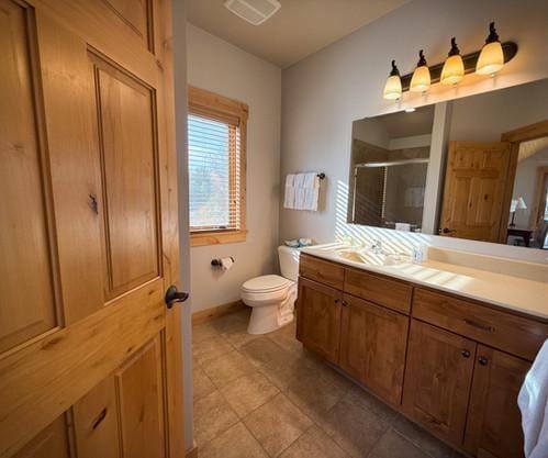 bathroom with vanity, an enclosed shower, and toilet