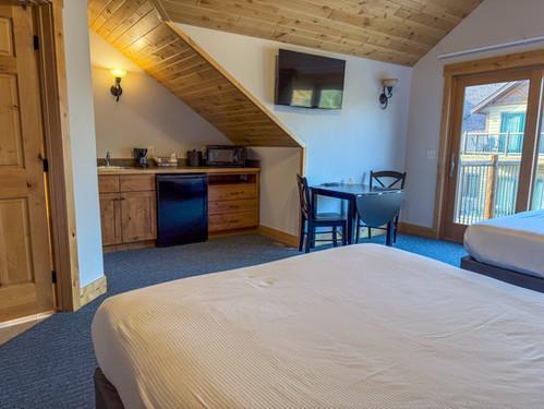 bedroom with bar, vaulted ceiling, wooden ceiling, fridge, and dark carpet