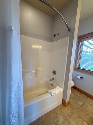 bathroom featuring shower / bath combination with curtain and toilet