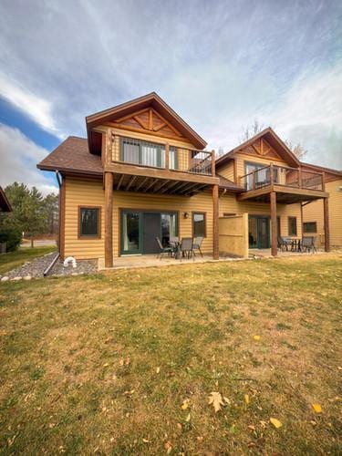 rear view of house featuring a yard, a patio area, and a balcony