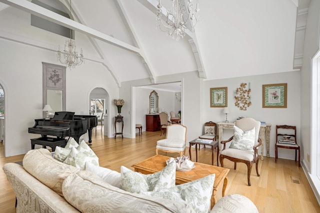 living room featuring arched walkways, a notable chandelier, light wood-style floors, high vaulted ceiling, and beam ceiling