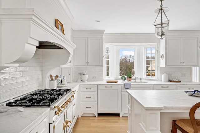 kitchen with decorative light fixtures, custom exhaust hood, light wood-style flooring, white cabinets, and a sink