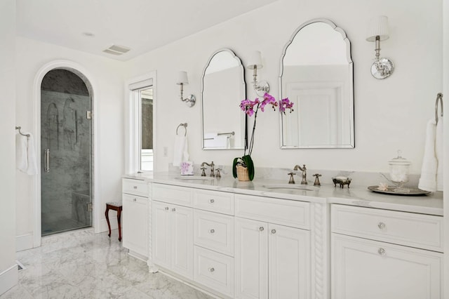 full bath with marble finish floor, visible vents, a sink, and a shower stall