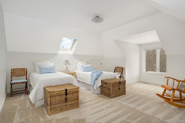 bedroom featuring carpet floors, vaulted ceiling with skylight, and baseboards