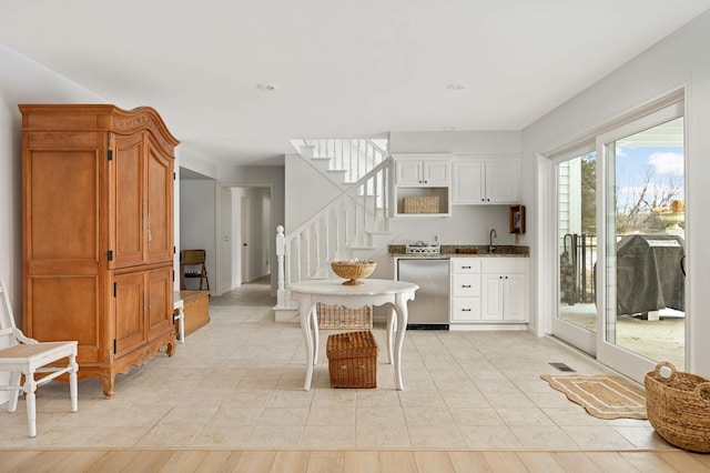 kitchen with a sink, dishwasher, and light tile patterned flooring