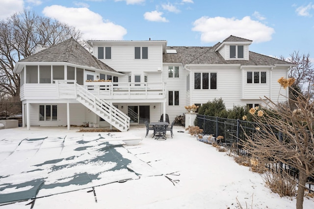 rear view of property with a sunroom, a patio area, fence, a deck, and stairs