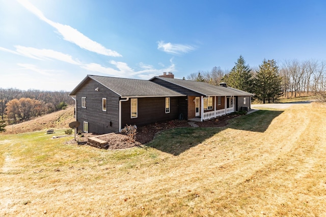 view of property exterior featuring covered porch and a lawn