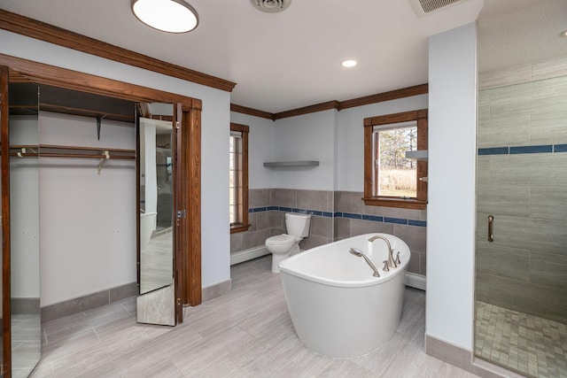 2700 115th St NW, Oronoco, MN 55960 - bathroom featuring a soaking tub, tile walls, a shower stall, and ornamental molding