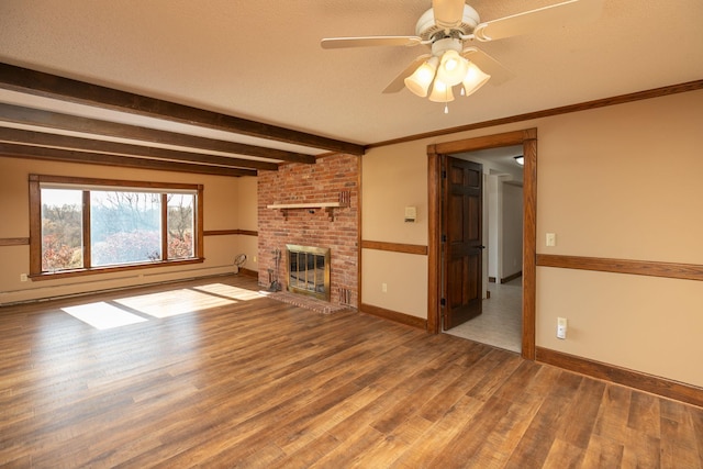 2700 115th St NW, Oronoco, MN 55960 - unfurnished living room with a ceiling fan, baseboard heating, a brick fireplace, wood finished floors, and baseboards