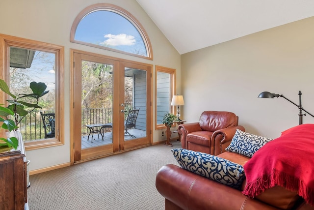 carpeted living room with french doors and high vaulted ceiling