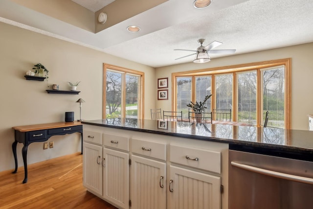 kitchen featuring stainless steel dishwasher, a textured ceiling, ceiling fan, light hardwood / wood-style floors, and white cabinetry