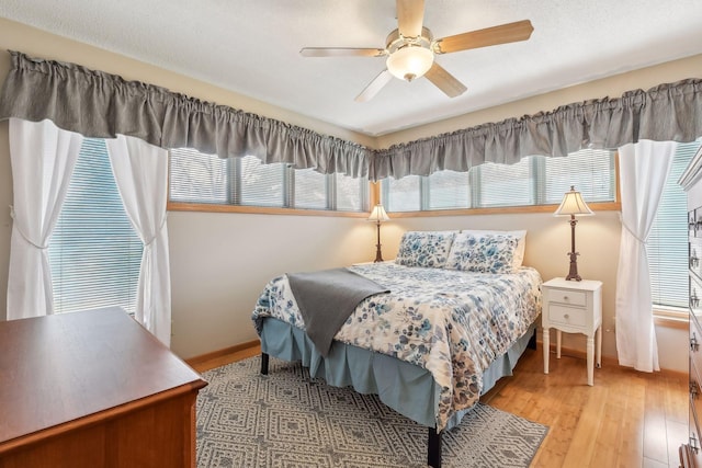 bedroom with ceiling fan and light hardwood / wood-style flooring