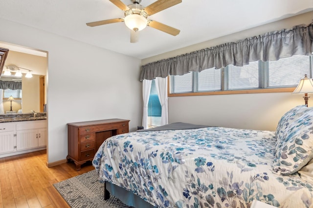 bedroom with connected bathroom, ceiling fan, and light wood-type flooring